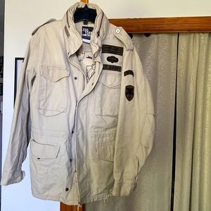 Beige khaki men’s medium spring coat with zip up hood. Army green patches/detail